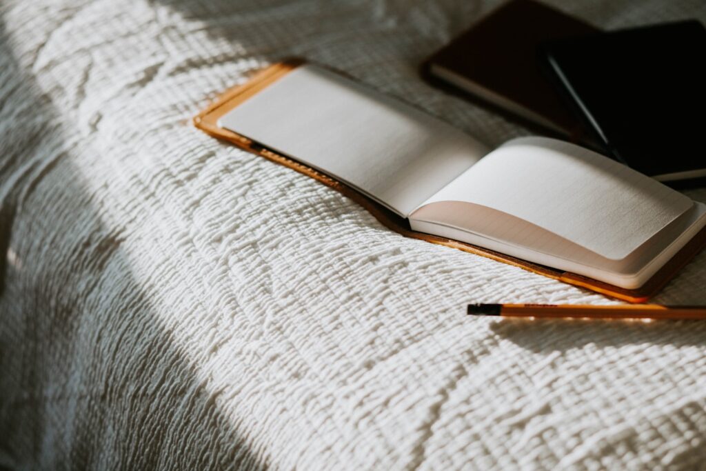 Offenes Notizbuch auf einem Bett